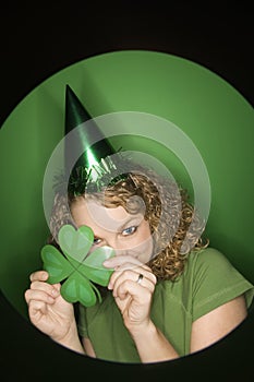 Young Caucasian woman holding shamrock.