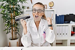 Young caucasian woman holding teeth whitening palette pointing finger up with successful idea