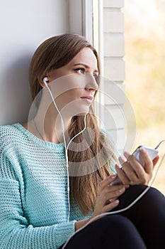 Young caucasian woman is listening to music