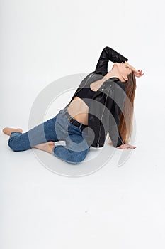 young caucasian woman with long brown hair in leather jacket on white background