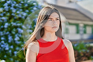 Young caucasian woman looking to the side with serious expression at park