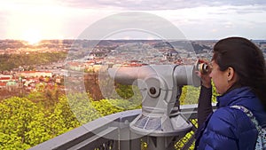 Young caucasian woman looks to the binoculars