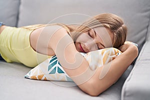 Young caucasian woman lying on sofa sleeping at home