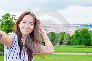 Young caucasian woman making selfie background european old city by mobile phone from the observation place