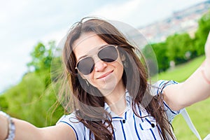 Young caucasian woman making selfie background european old city by mobile phone from the observation place