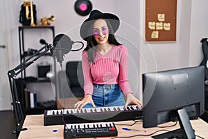 Young caucasian woman musician singing song playing piano at music studio