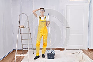 Young caucasian woman painting walls confuse and wondering about question