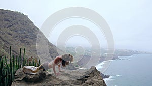 Young Caucasian woman performing upward facing dog pose outdoors