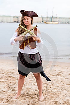 Young Caucasian woman in pirate costume crossed toy guns in front of her