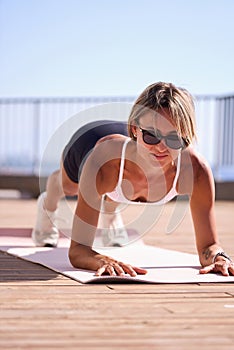 young caucasian woman in plank position, exercising outdoors. stretch whole body, lead healthy lifestyle