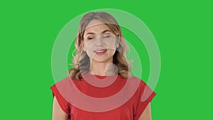 Young caucasian woman pointing with hand and finger to the side on a Green Screen, Chroma Key.