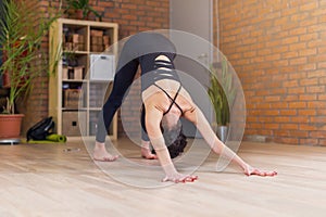 Young Caucasian woman practicing yoga doing downward facing dog position