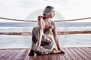 Young caucasian woman practicing yoga, sitting in Ardha Matsyendrasana. Half spinal twist pose. Bali, Indonesia