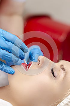 Young Caucasian Woman During a Process of Permanent Lips Makeup in Tattoo Salon  Closeup