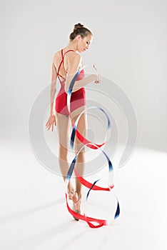 Young caucasian woman rhythmic gymnast posing with colorful rope