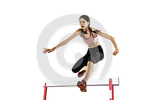 Young caucasian woman running, jumping isolated on white studio background. One female runner or jogger. Sport, track