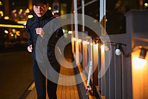 young caucasian woman running by night in city street. Fitness and workout wellness concept