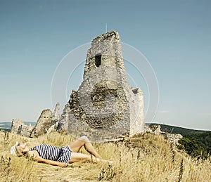 Young caucasian woman in a sailor outfit lying on the dry grass