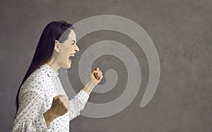 Young caucasian woman screaming showing furious face side view portrait