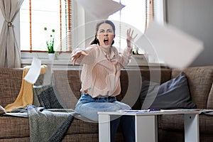 Young Caucasian woman screams and throws documents into camera. Business and mortgage concept