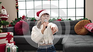 Young caucasian woman singing at home on christmas at home