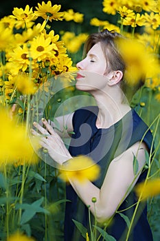 Young caucasian woman smelling yellow flowers with a pleasure