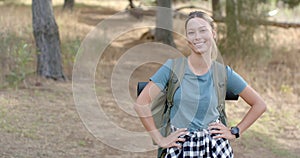 Young Caucasian woman smiles during a hike in the woods with copy space