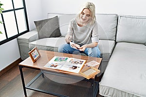 Young caucasian woman smiling confident decoring with frame at home