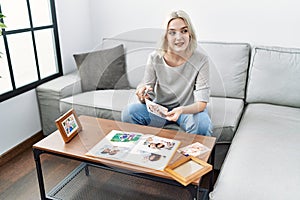 Young caucasian woman smiling confident decoring with frame at home