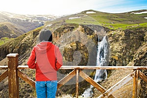 Young caucasian woman stand on viewpoint enjoy Susuz waterfall panorama