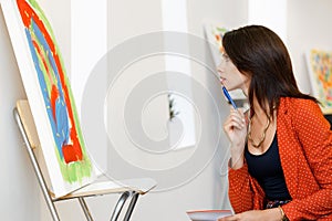 Young caucasian woman standing in art gallery front of paintings