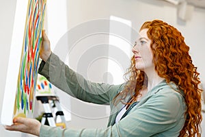 Young caucasian woman standing in art gallery front of paintings