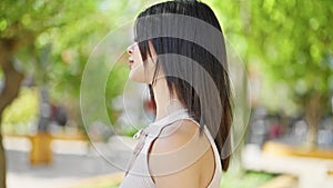 Young caucasian woman standing with serious expression walking away at park