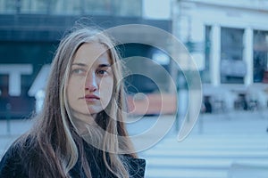 Young Caucasian woman standing at a street corner, looking away