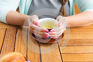 Young Caucasian woman with straight hair drinking tea in a coffee shop