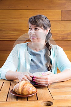 Young Caucasian woman with straight hair drinking tea in a coffee shop