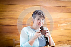 Young Caucasian woman with straight hair drinking tea in a coffee shop