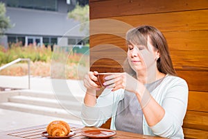 Young Caucasian woman with straight hair drinking tea in a coffee shop