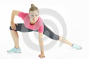 Young caucasian woman stretching legs warm up in studio isolated on white background