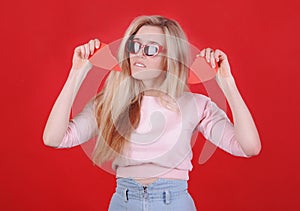 Young caucasian woman in sunglasses with broken red heart in hands.