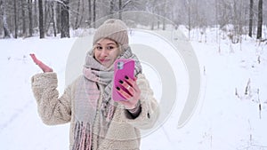 Young caucasian woman talking deaf Russian over video communication on smartphone outdoors in winter.