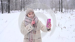 Young caucasian woman talking deaf Russian over video communication on smartphone outdoors in winter.