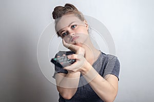 Young caucasian woman with a tv remote control looking bored at home quarantine