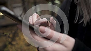 Young caucasian woman using phone in the city sleeping area in front of residential house in autumn. Action. Close up of