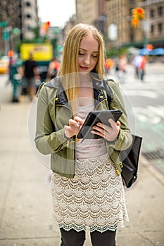 Young caucasian woman using tablet in city