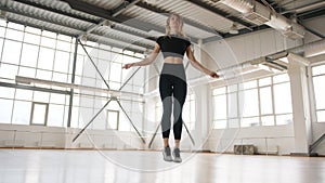 Young, caucasian woman warming up in a gym studio