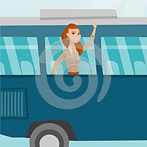 Young caucasian woman waving hand from bus window.