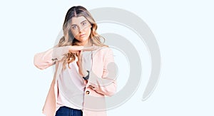 Young caucasian woman wearing business clothes doing time out gesture with hands, frustrated and serious face