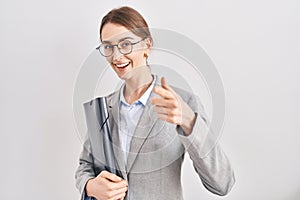 Young caucasian woman wearing business clothes and glasses pointing fingers to camera with happy and funny face
