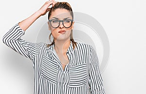 Young caucasian woman wearing business shirt and glasses confuse and wonder about question